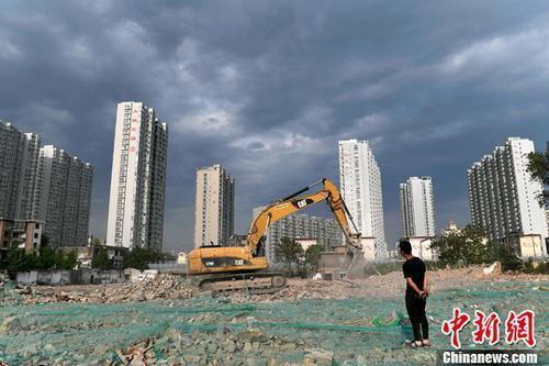 资料图：工人操作挖掘机在山西太原一商品房建设工地施工作业。<a target='_blank' href='http://www.chinanews.com/'>中新社</a>记者 韦亮 摄